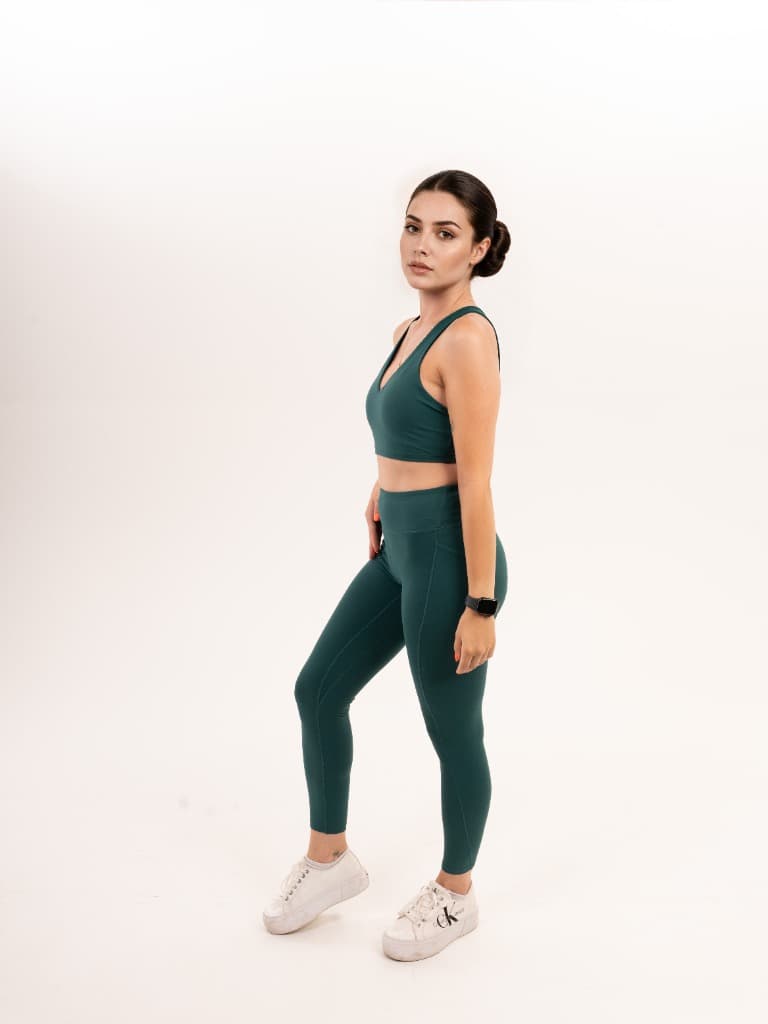 Model in a green sports bra and leggings, side view – Variant 1