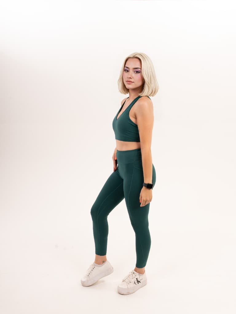 Model in a green sports bra and leggings, side view – Variant 3