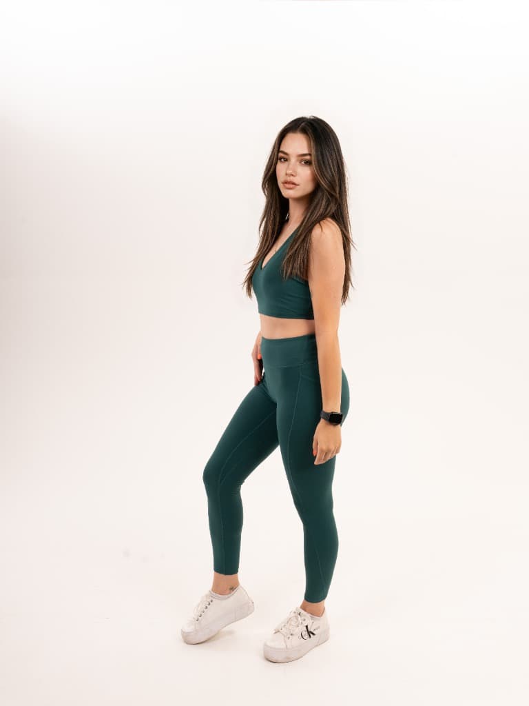 Model in a green sports bra and leggings, side view – Variant 4